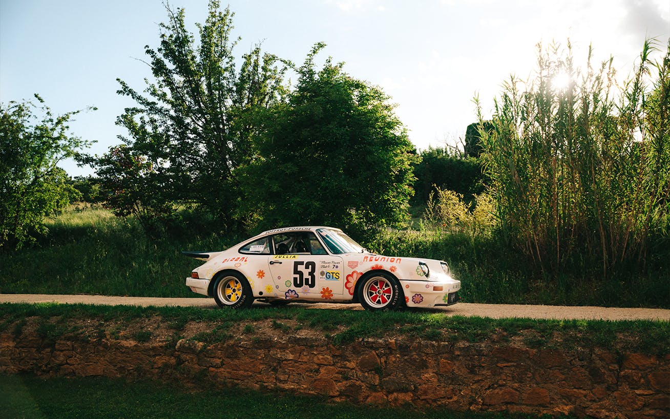 Side view of Porsche 3.0 RS parked on country road 