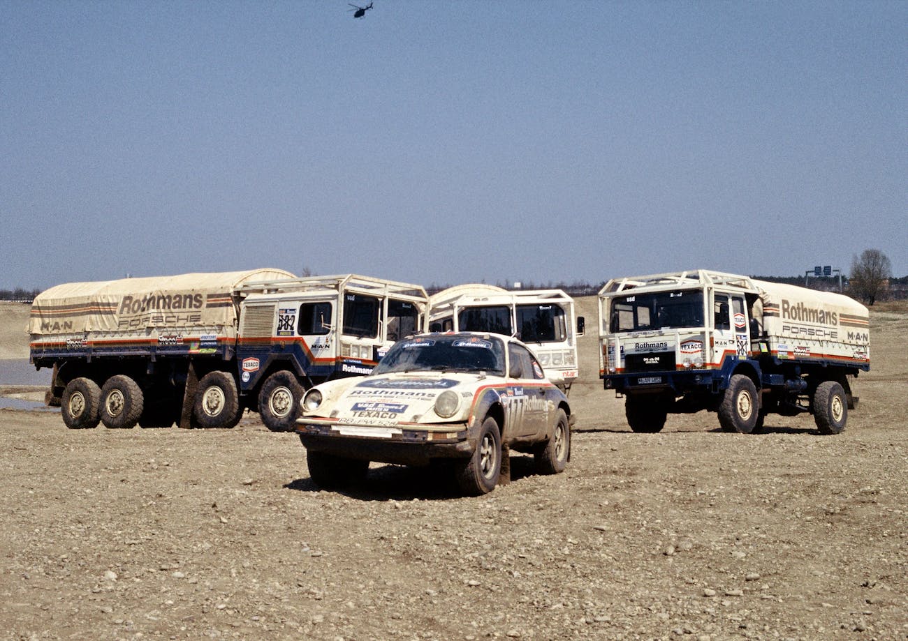 Porsche 911 rally car with support trucks for Paris-Dakar Rally