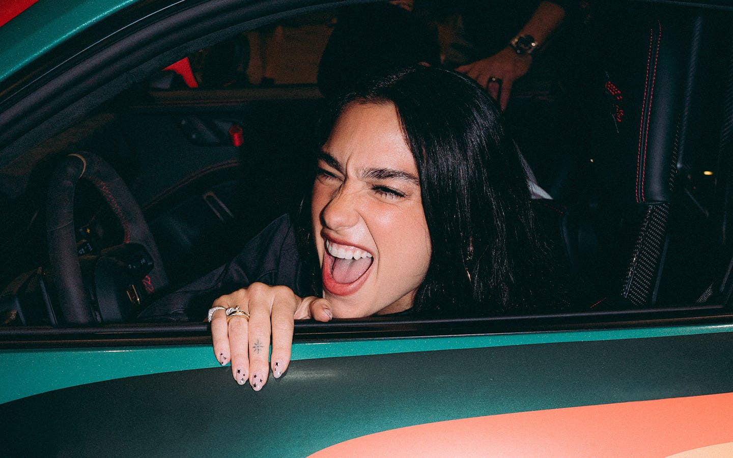 Dua Lipa sat in Dua Lipa Rennstall GT3 RS sportscar