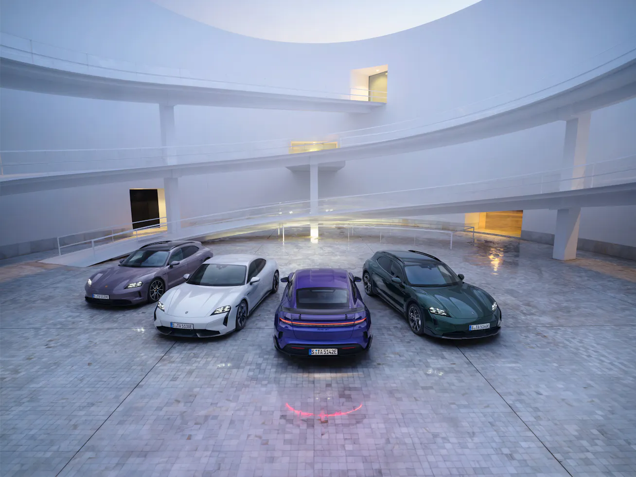 Image showing Porsche Taycan range with modern structure in background
