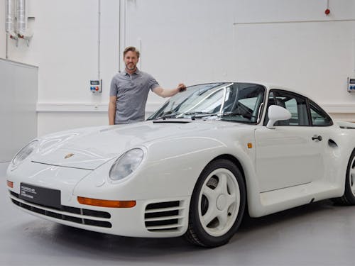 Nick Heidfeld standing behind white Porsche 959 S