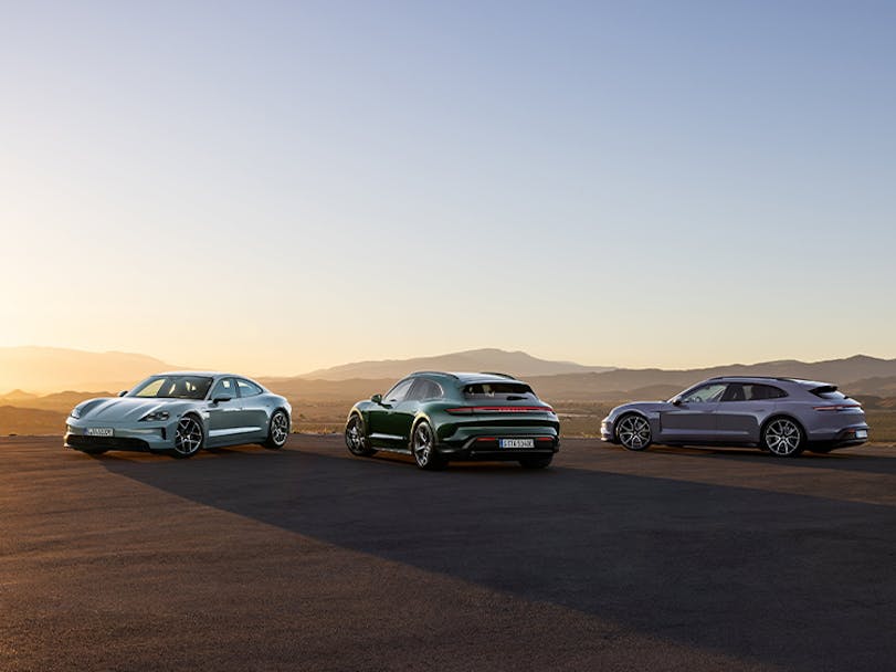 Porsche Taycan model range parked in desert setting at sunset