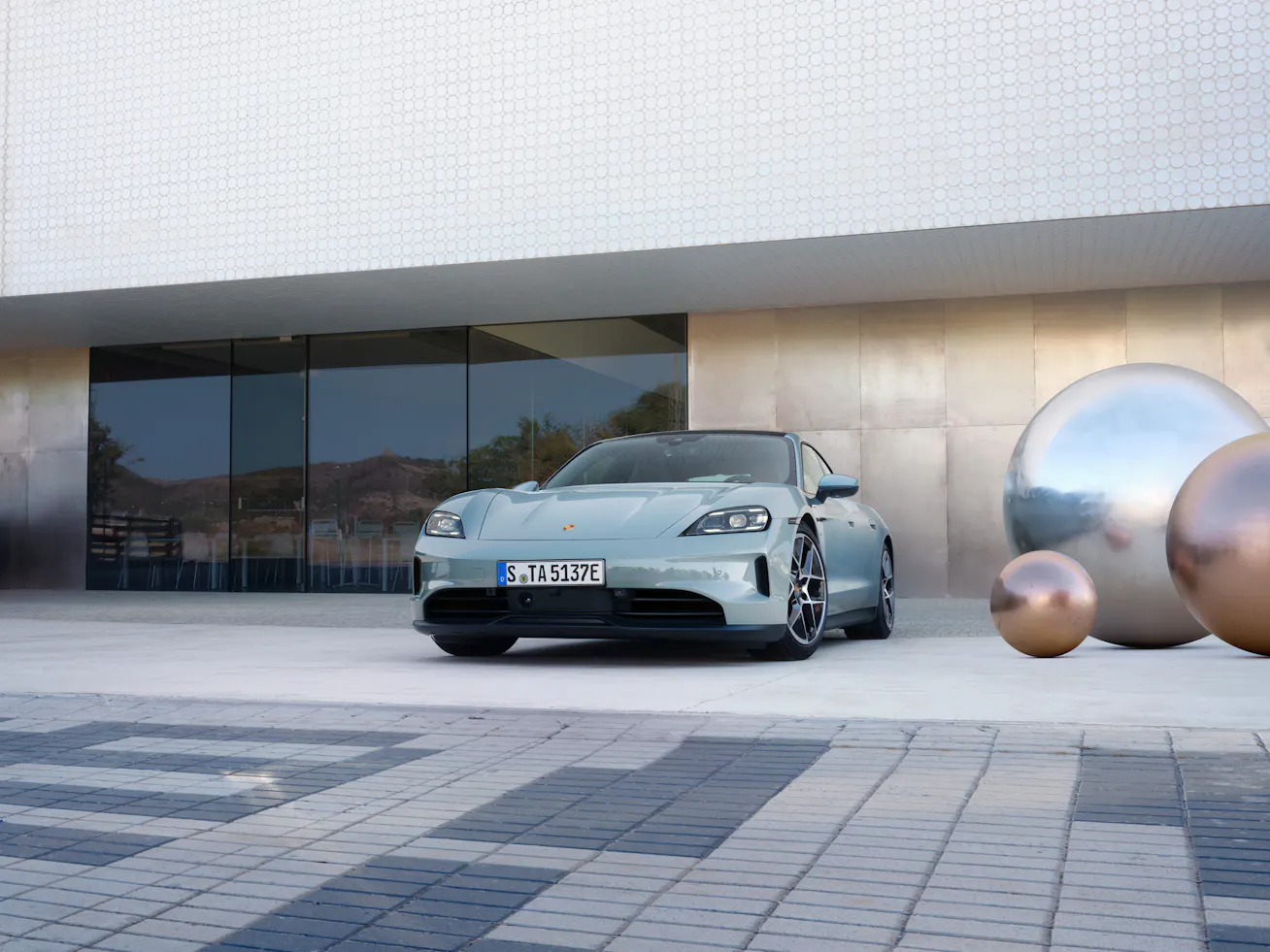 Porsche Taycan front shot parked in front of modern building