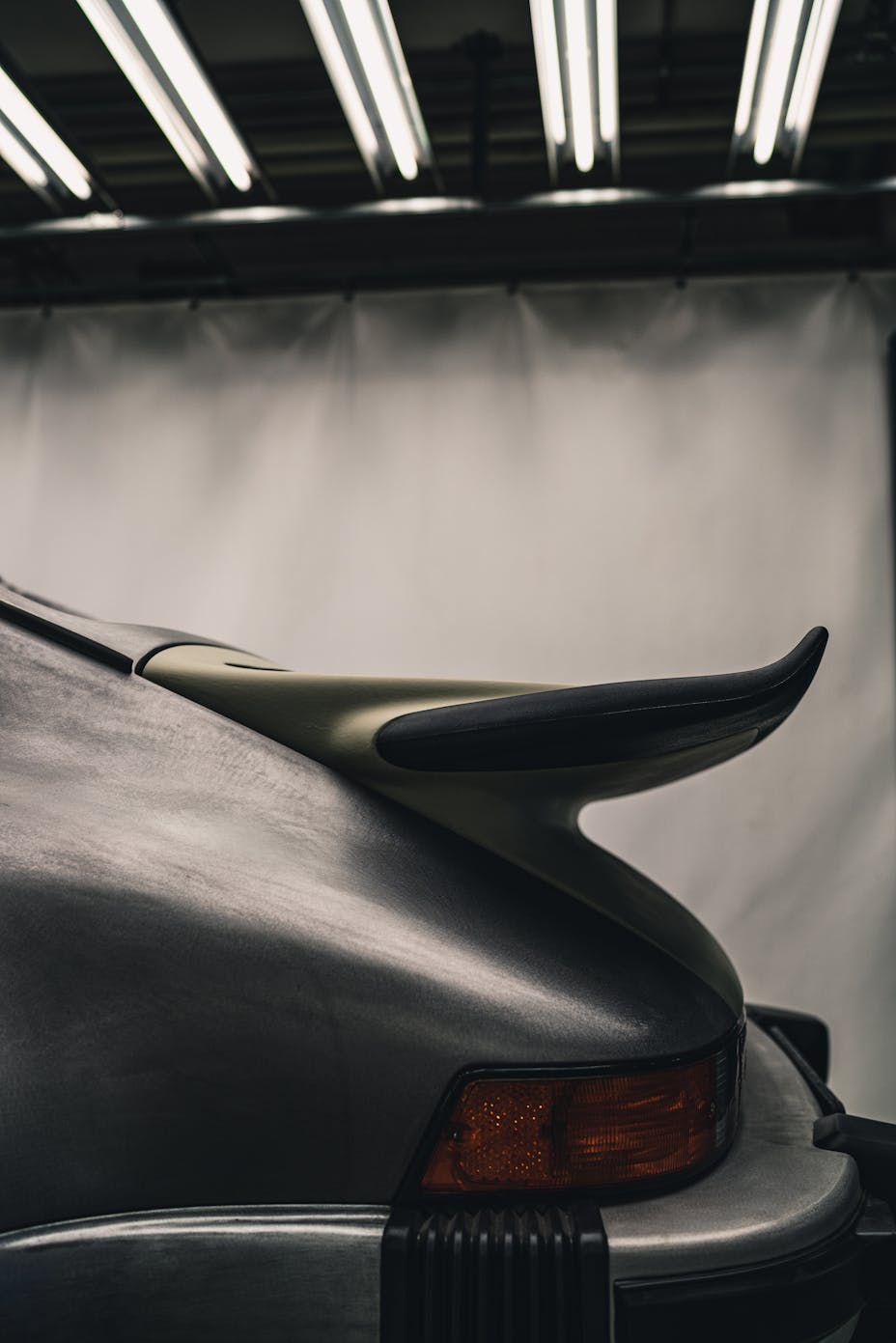 Close-up shot of whale tail rear wing on silver Porsche