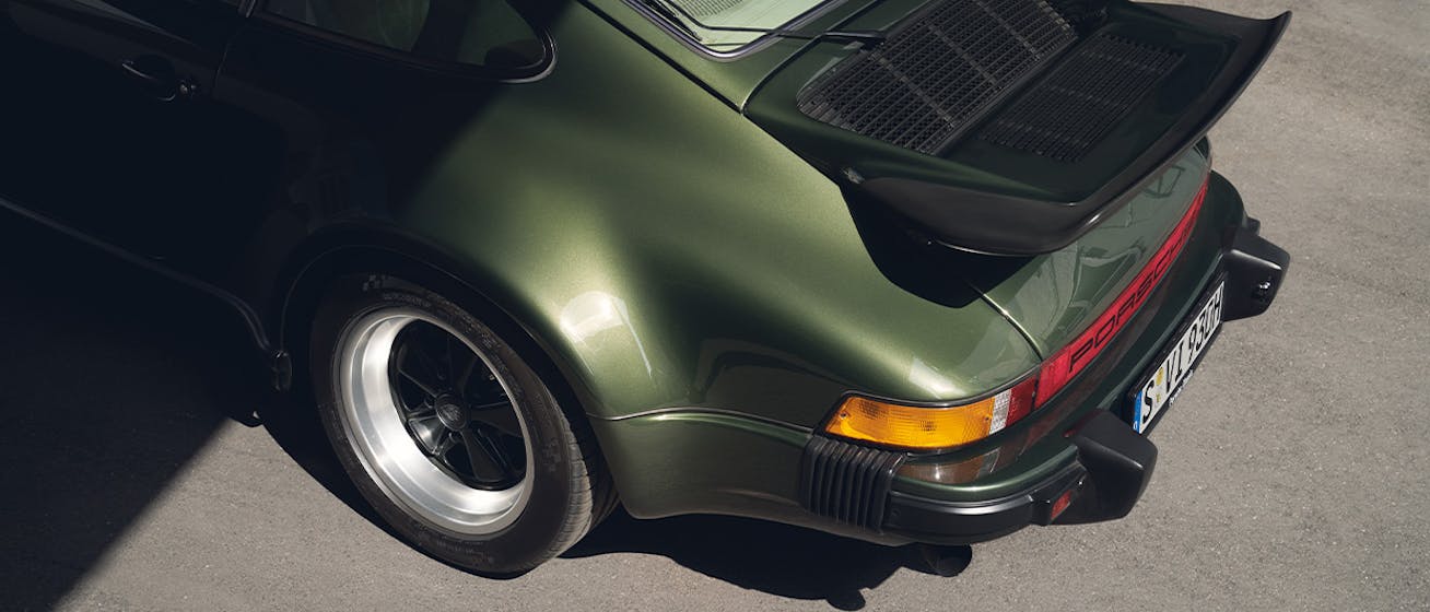 Rear view of green Porsche 930 Turbo in sunlight