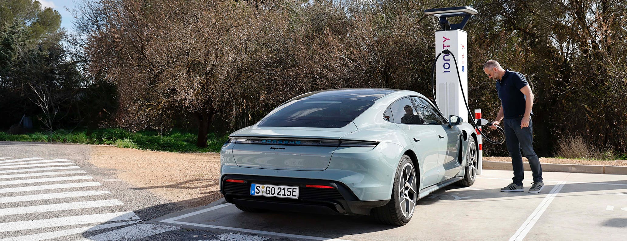 Man charges Porsche Taycan at charging station