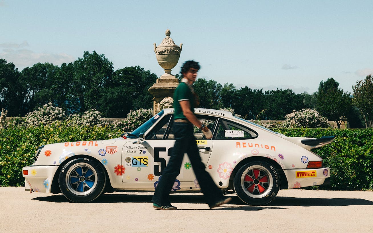 Man in front of parked Porsche 3.0 RS rally car 