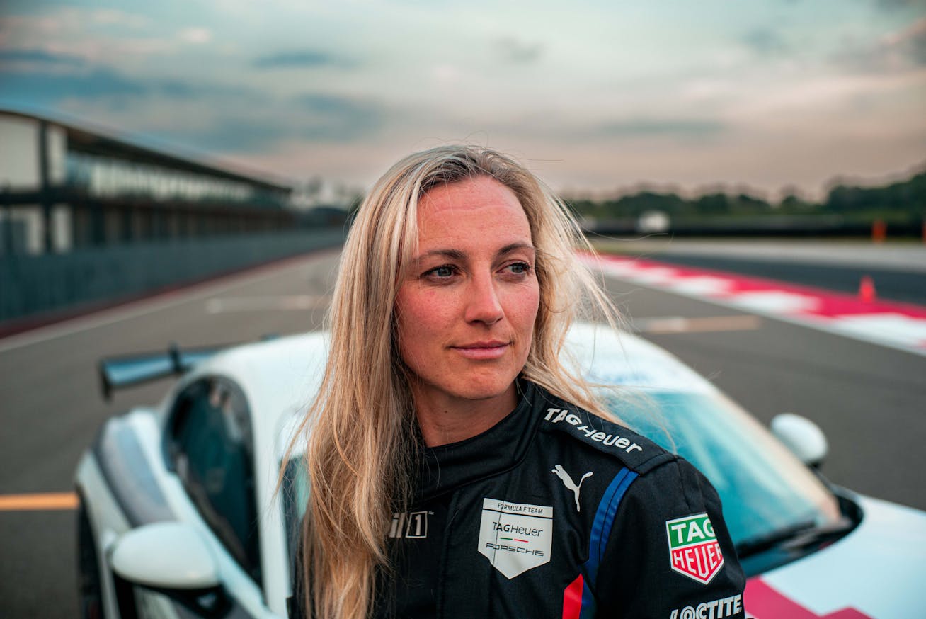 Woman with Porsche 718 Cayman GT4 RS on race track