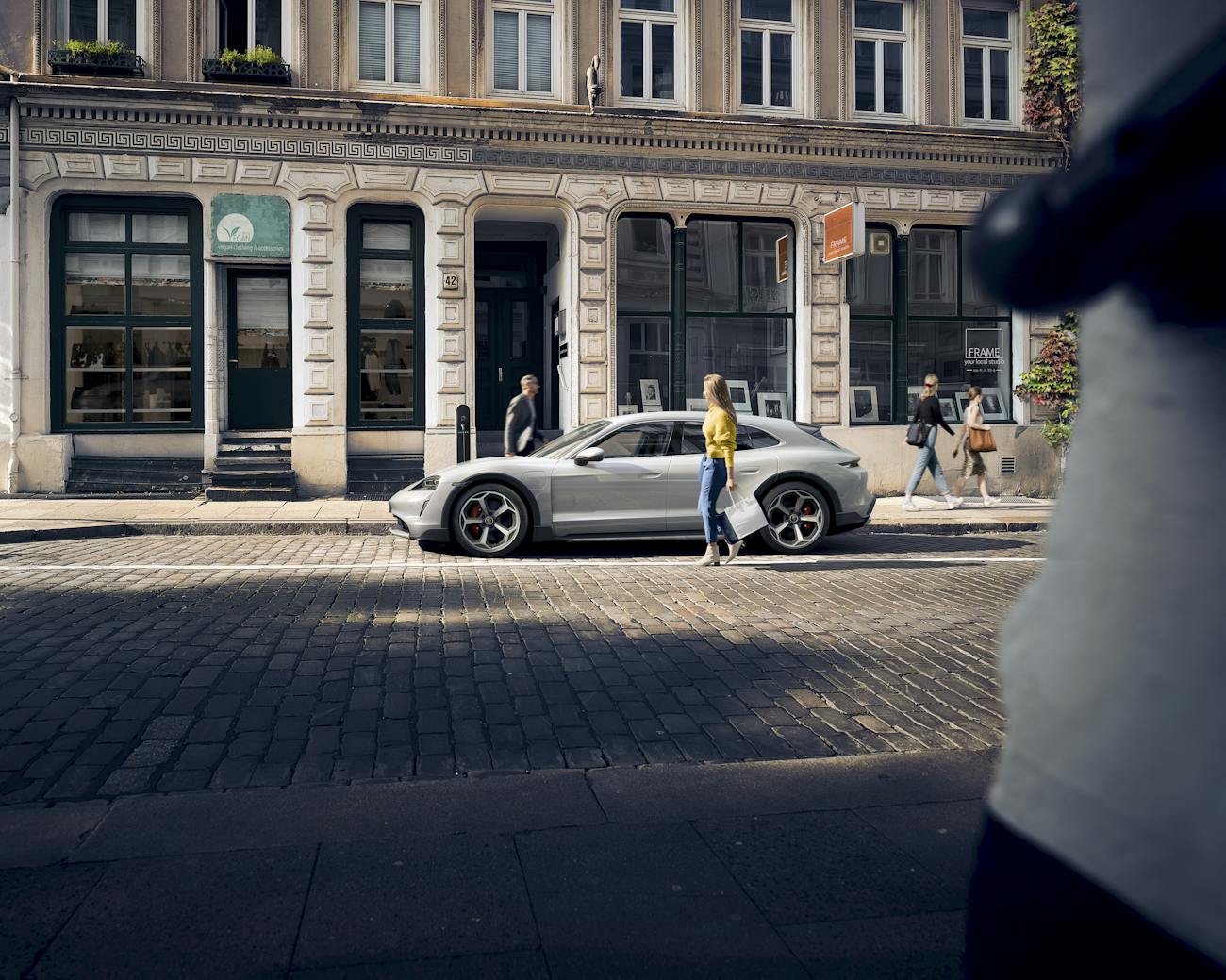 White Porsche Taycan Cross Turismo parked up in shopping street