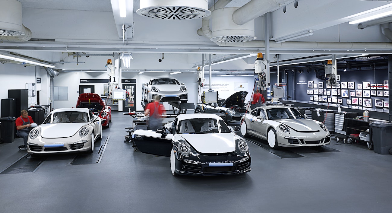 Inside a garage showing range of Porsche models being sprayed