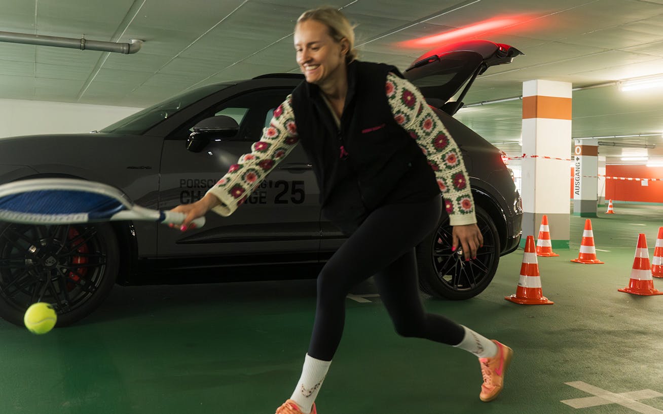 Iron Dames’ Michelle Gatting hitting tennis ball, Porsche Macan behind