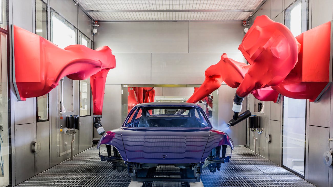 Porsche car being painted by robots in factory