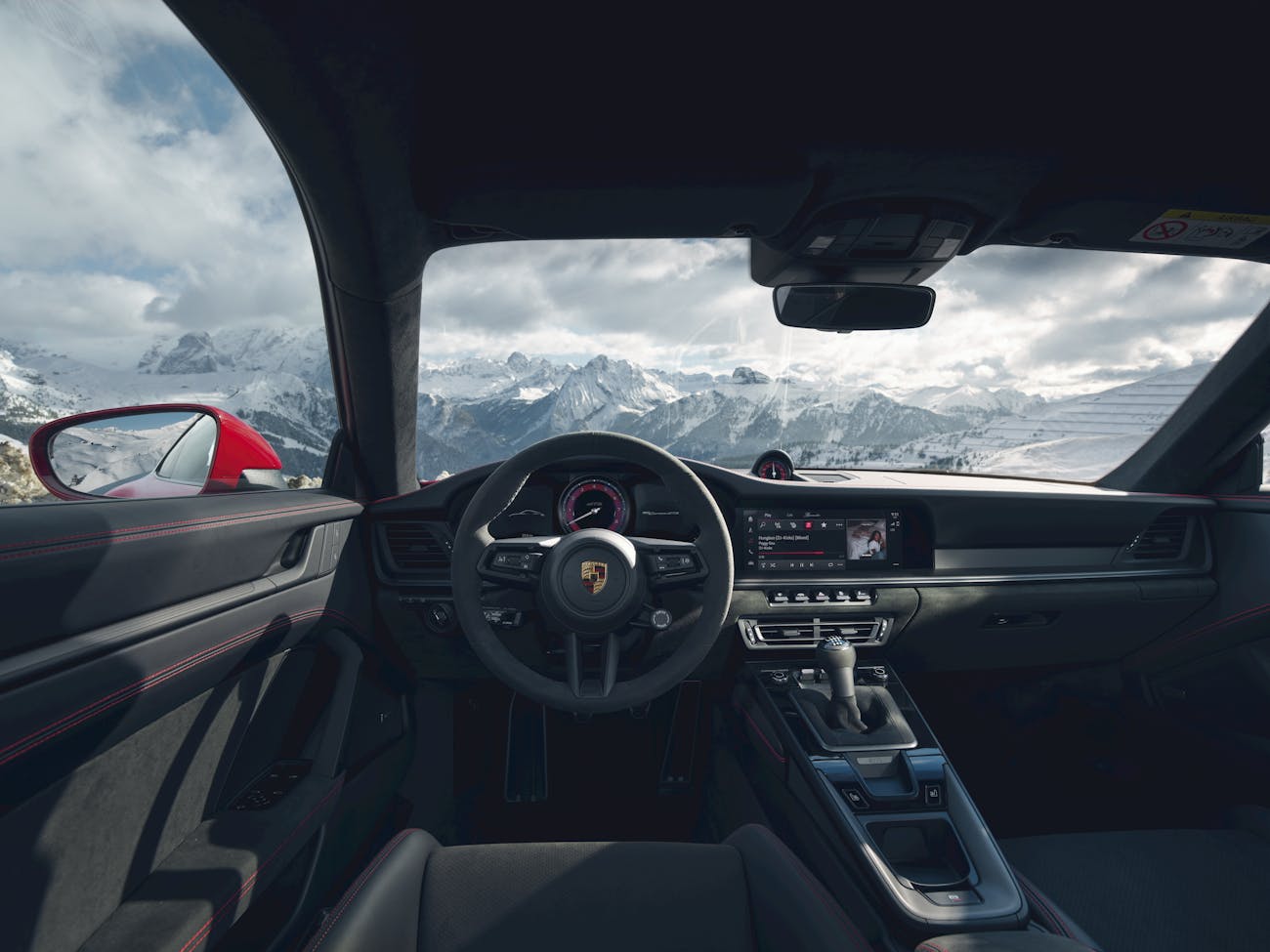 View from driver seat of Porsche 911 GTS out onto mountains