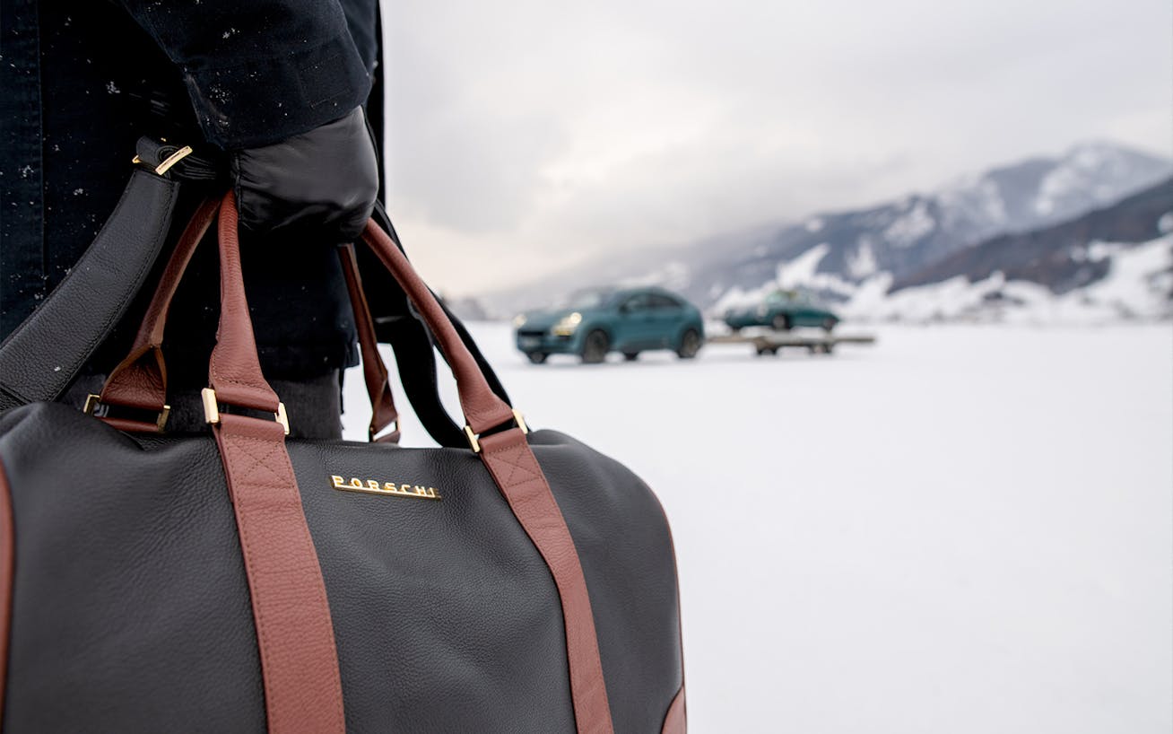 Close-up of Porsche Classic Touring Bag, winter landscape behind