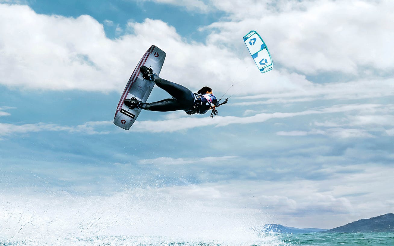 Kitesurfer soars in the sky above the sea