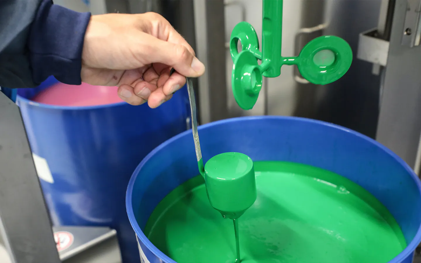 Man checking pot of green paint used for Porsche Paint To Sample