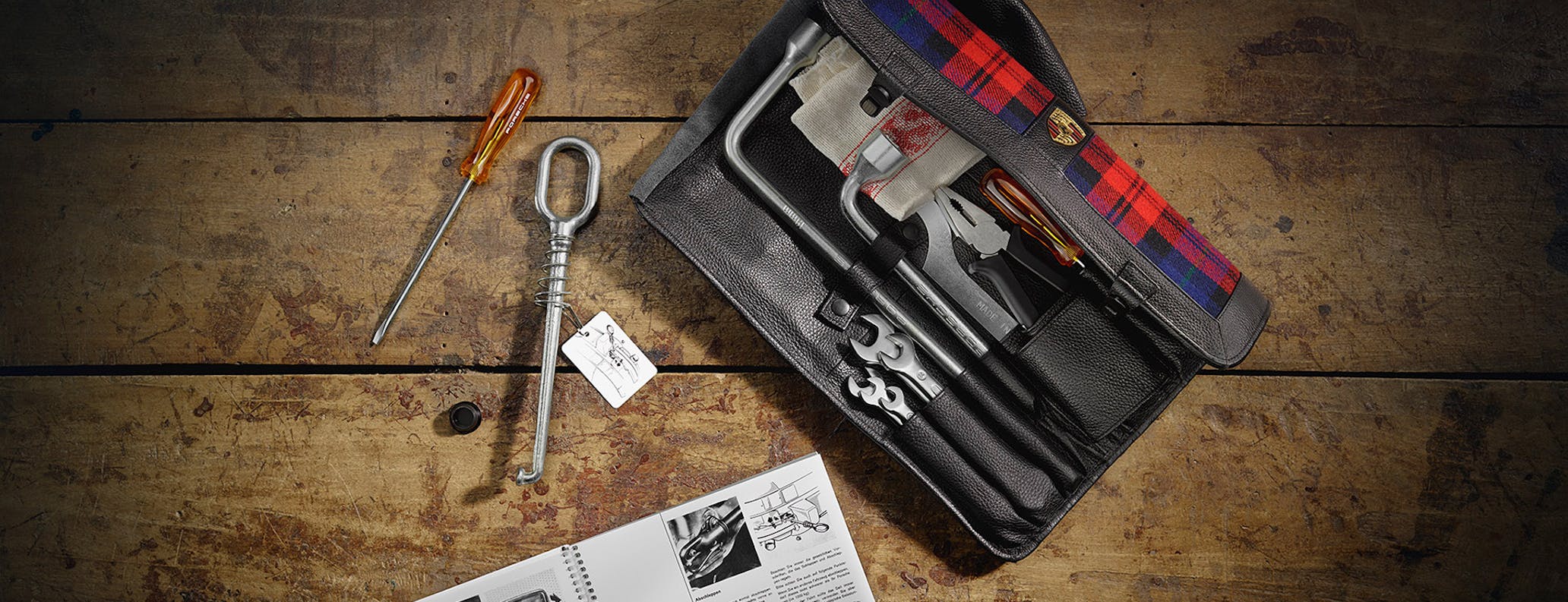 Overhead view of classic Porsche tool bag on wooden workbench