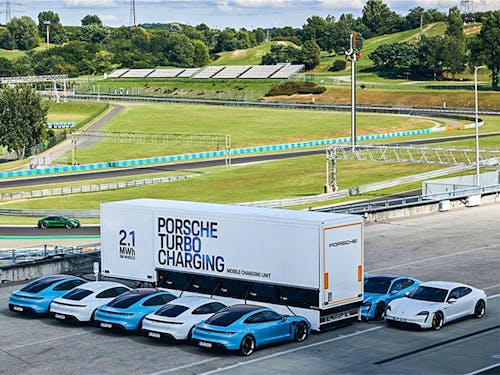 Porsche Taycan electric sportscars hooked up to a charging trailer