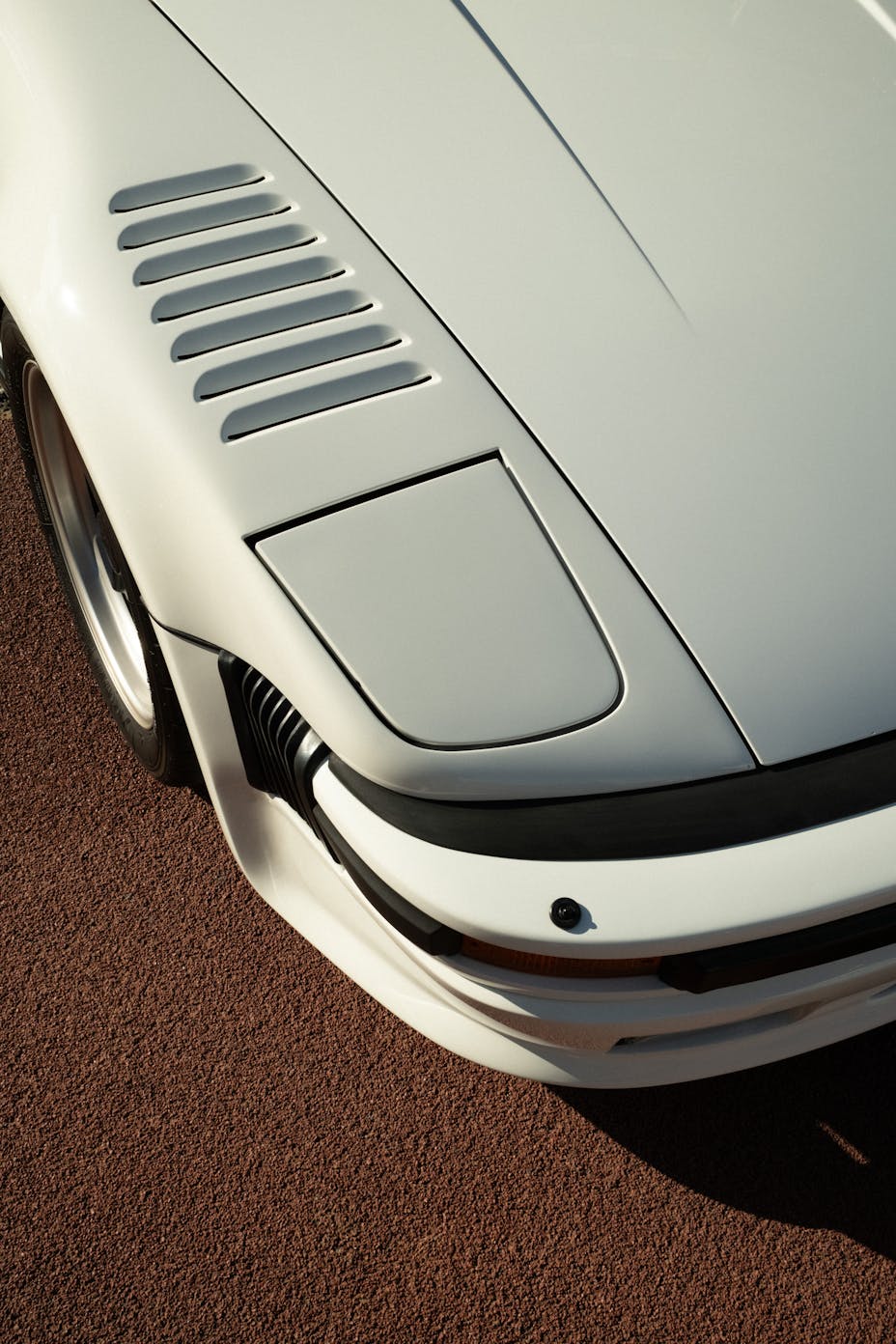 Close-up detail of a Slantnose Porsche 911 with pop-up headlights and front wing cooling vents