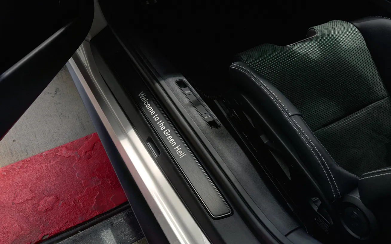 View of interior of Porsche 911 GT3 100 Jahre Nürburgring showing door sill trim with words Welcome To The Green Hell