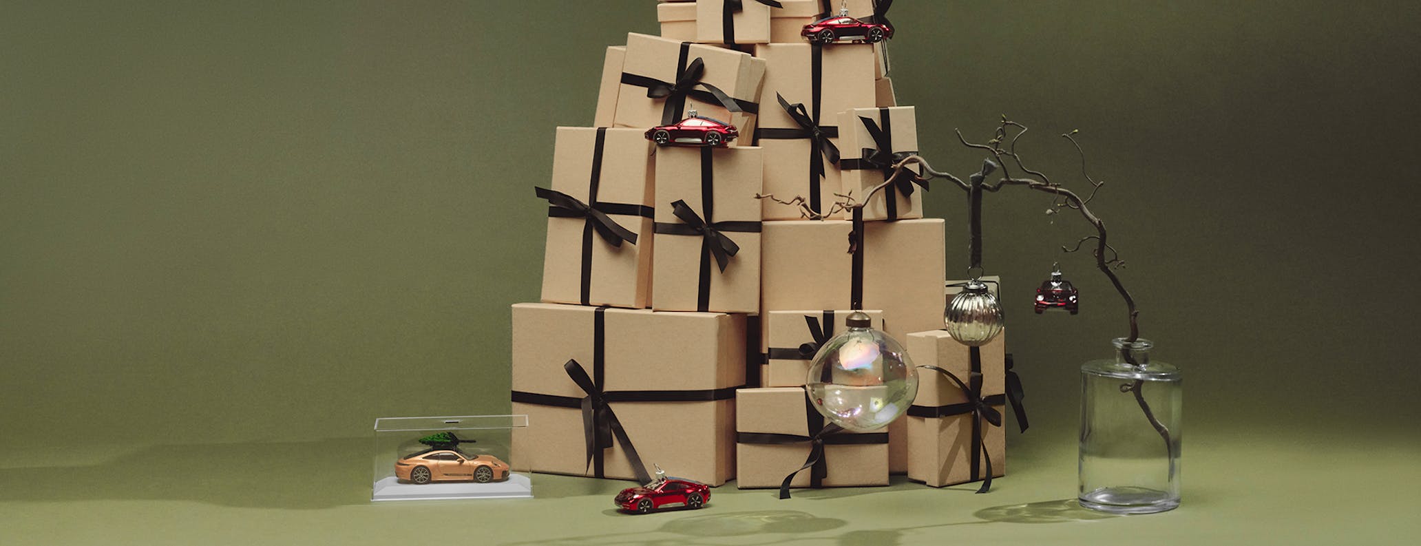 Holiday gift boxes decorated with miniature Porsche cars and ornaments 