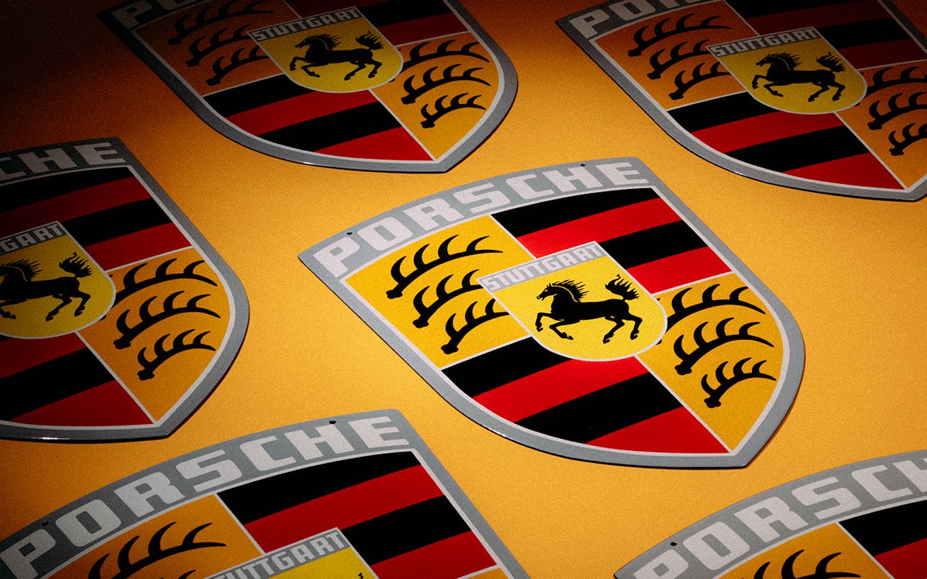 Porsche Crest enamel plates displayed on yellow background 