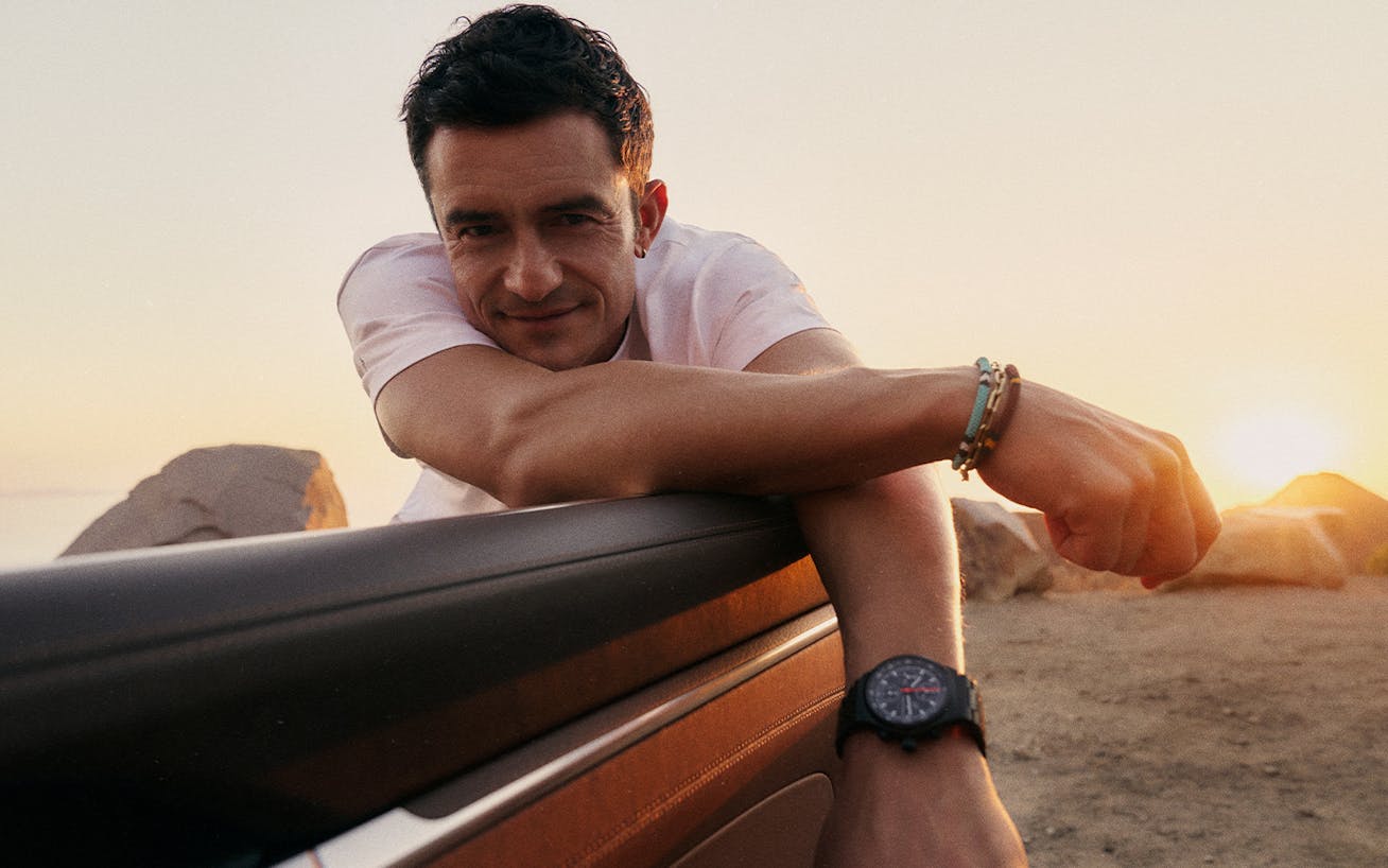 Close-up of Orlando Bloom leaning over open Porsche door