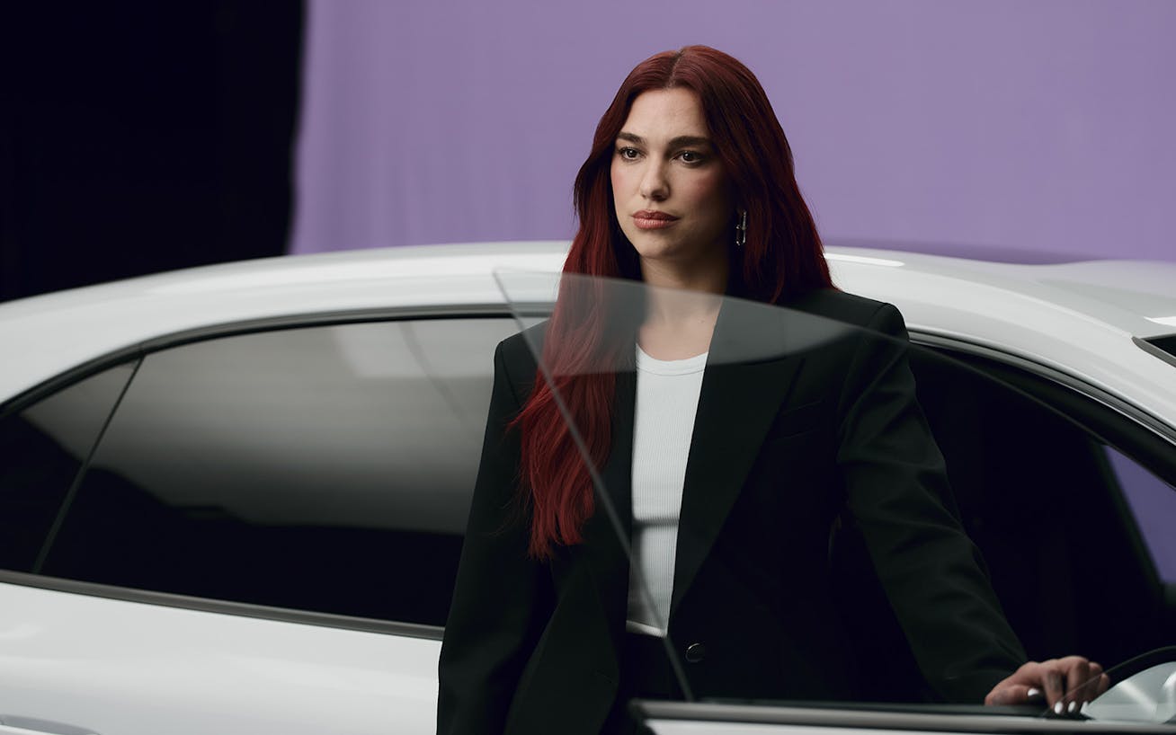 Dua Lipa sat on roof of all-electric Porsche Macan