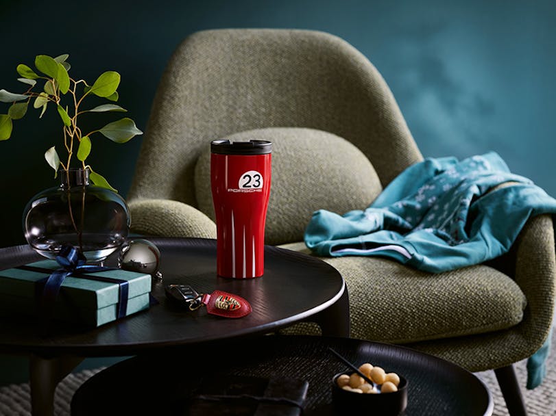 Coffee mug and Porsche key ring on living room table 