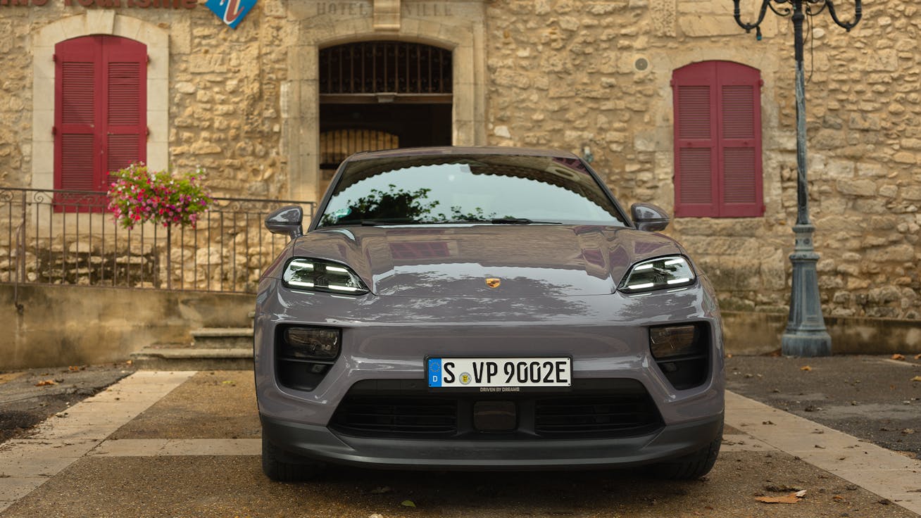 Porsche Macan 4 Electric parked outside traditional Provençal stone building