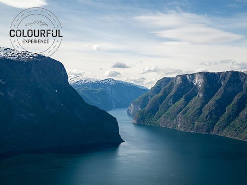 Sunlit Norwegian fjord with still waters and blue sky