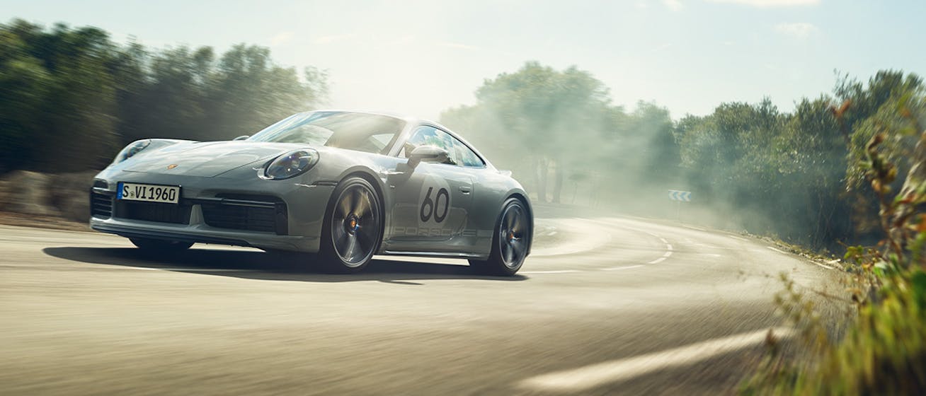 Grey Porsche 911 Sport Classic driving through a sunlit corner