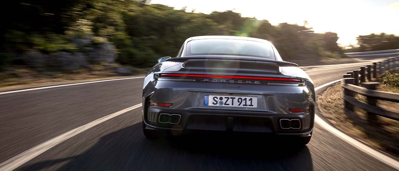 Porsche 911 Turbo S cornering on sunlit road
