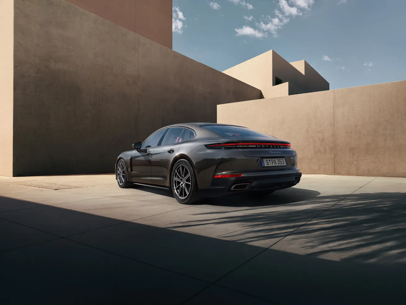 Rear view of Porsche Panamera with modern structure in the background