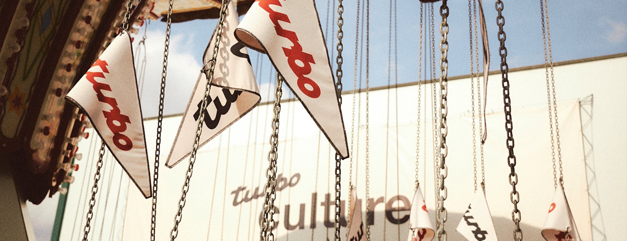 Merry-go-round decorated with white flags bearing the Porsche Turbo logo 