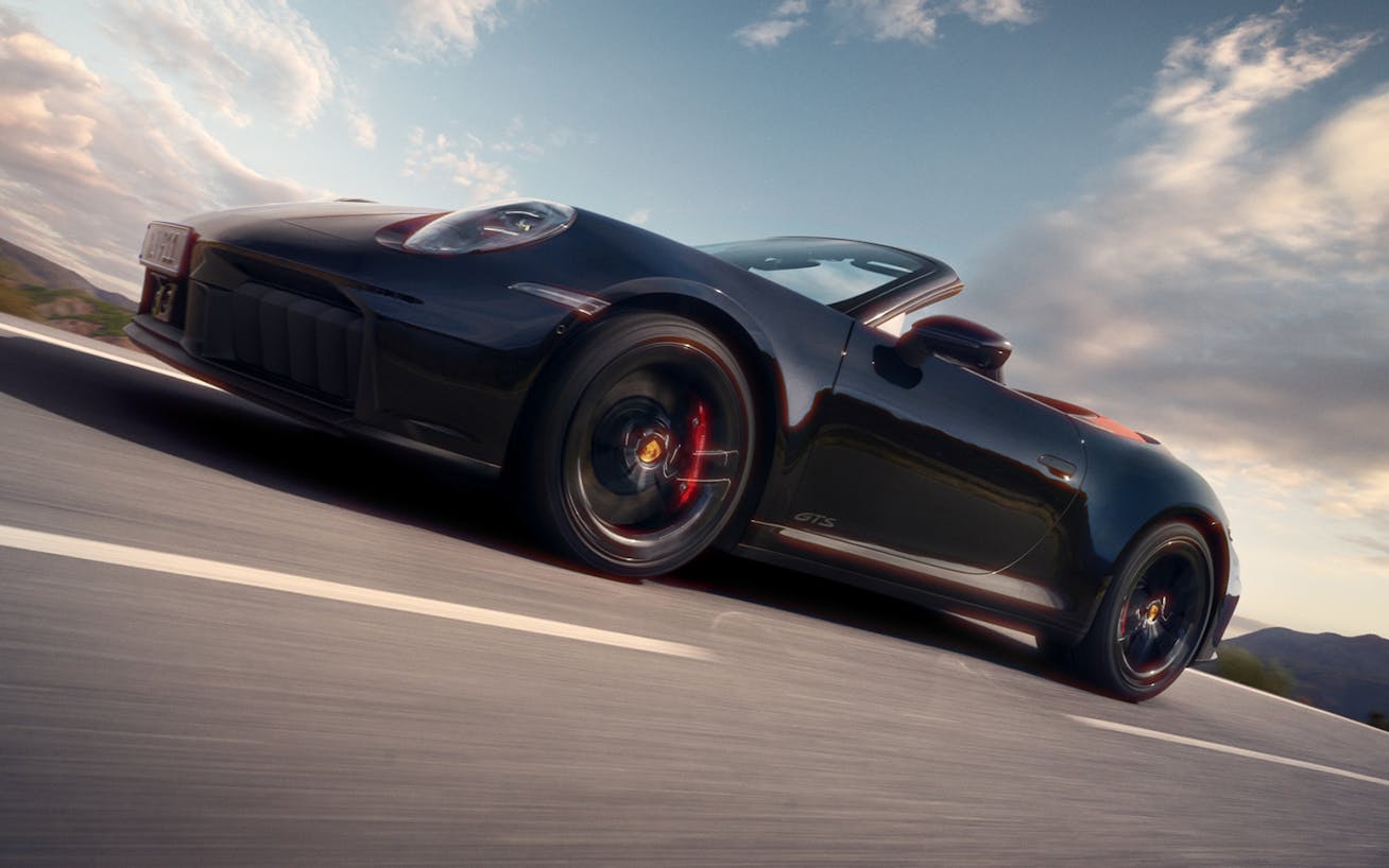Black Porsche 911 Carrera GTS (992.2) Cabriolet driving on road