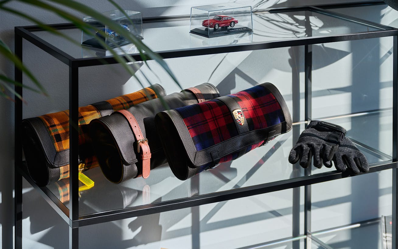 Three Porsche Classic Tool Bags sitting on a glass shelf