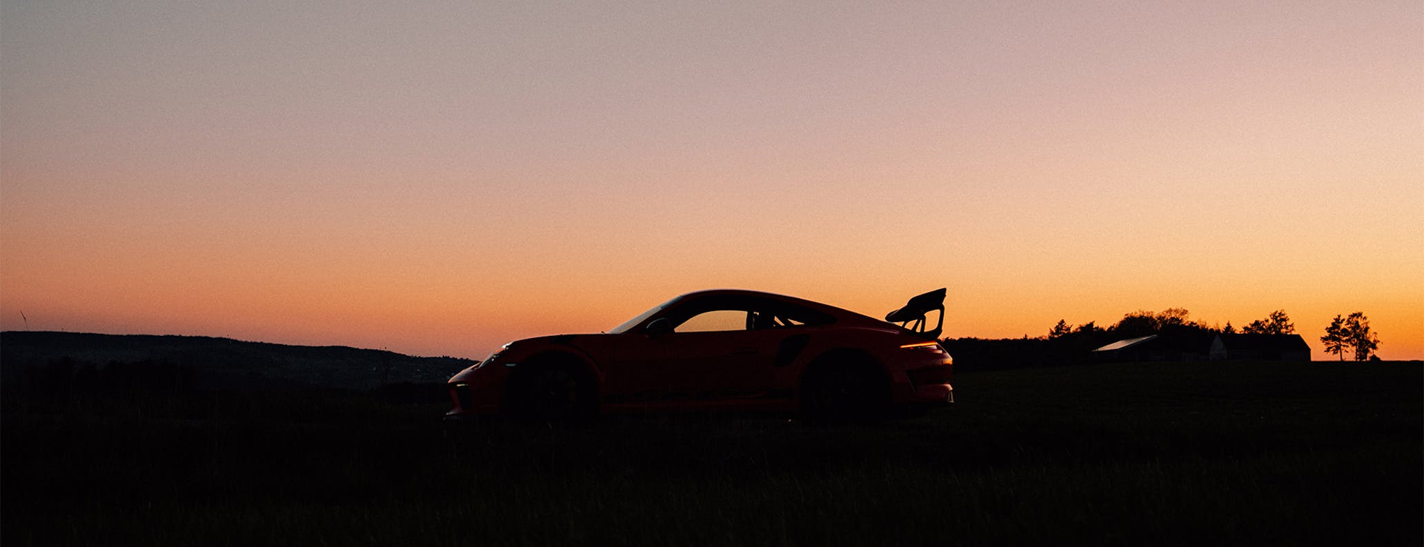 Porsche 911 GT3 RS in silhouette at sunset 